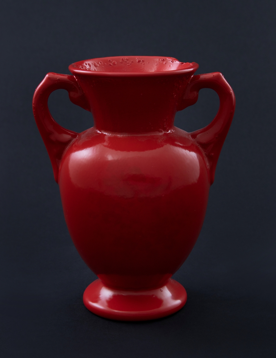 Rødlakkert keramisk vase. Amforaform med rundt korpus og konisk hals. Håndtak som ligner på svanehalser. 
Vasen er en readymade, altså et funnet objekt, som kunstneren har brennlakkert. Transformasjonen gjør at kun vaseformen står igjen, mens individuell glasur, farge og eventuelt motiv er gjemt bak den nye, monokrome, blanke overflaten. I følge kunstneren er de faktiske objektene funnet i antikvitetsbutikker og loppemarkeder, og er antakelig laget i løpet av de siste 100 år.