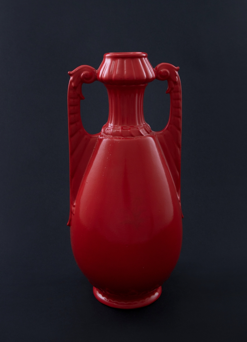 Rødlakkert keramisk vase. Amfora med balusterformet kropp, smal hals med riller og buklet munning. Håndtakene er dekorert med linjer og har spiralform øverst. Bladornament nederst på korpus.  
Vasen er en readymade, altså et funnet objekt, som kunstneren har brennlakkert. Transformasjonen gjør at kun vaseformen står igjen, mens individuell glasur, farge og eventuelt motiv er gjemt bak den nye, monokrome, blanke overflaten. I følge kunstneren er de faktiske objektene funnet i antikvitetsbutikker og loppemarkeder, og er antakelig laget i løpet av de siste 100 år.