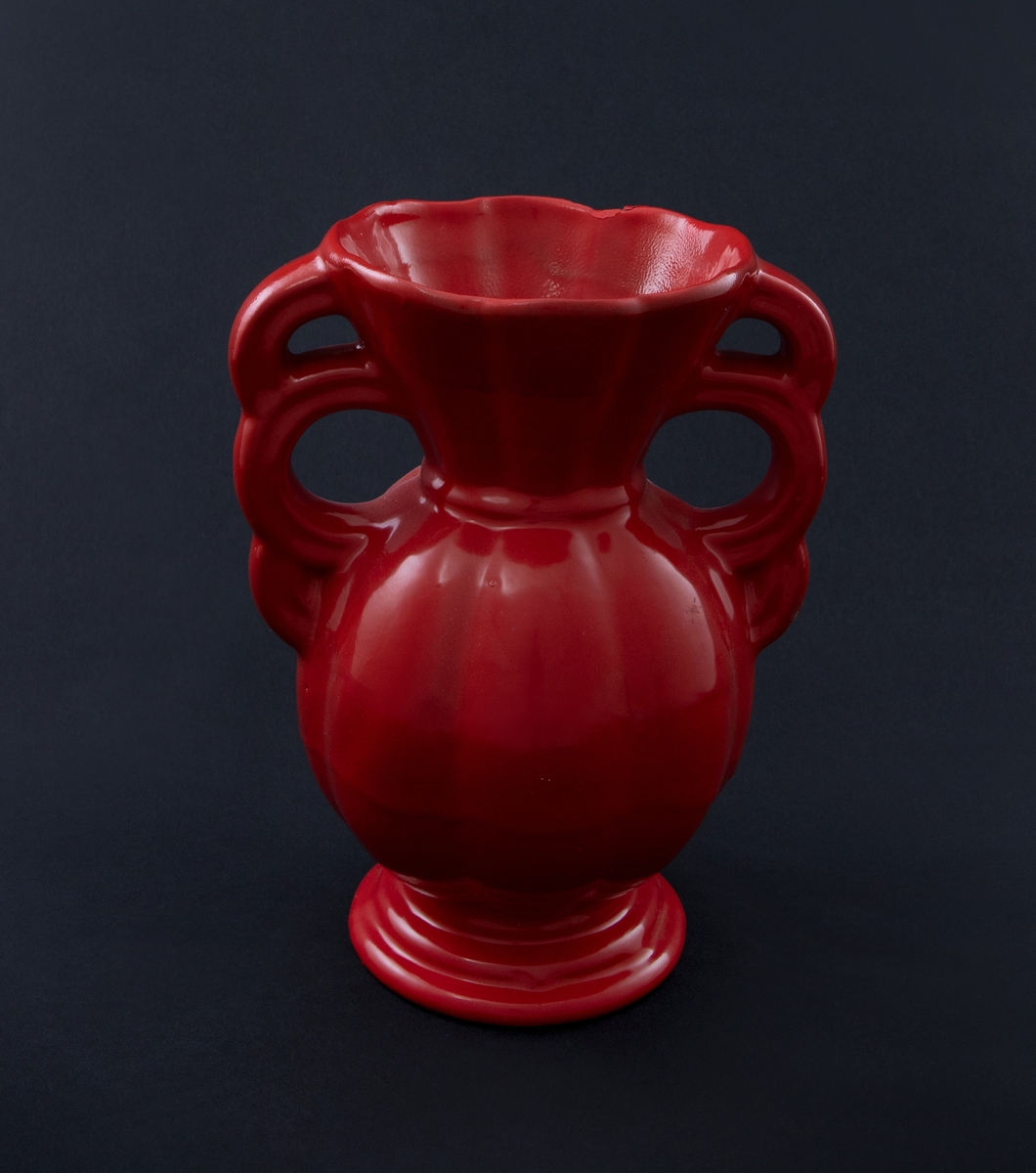 Rødlakkert keramisk vase. Amforaform med buklet rundt korpus og konisk hals med bukler. Vid munning med bølgeformet rand. Tredelte, sirkelformede håndtak. 
Vasen er en readymade, altså et funnet objekt, som kunstneren har brennlakkert. Transformasjonen gjør at kun vaseformen står igjen, mens individuell glasur, farge og eventuelt motiv er gjemt bak den nye, monokrome, blanke overflaten. I følge kunstneren er de faktiske objektene funnet i antikvitetsbutikker og loppemarkeder, og er antakelig laget i løpet av de siste 100 år.