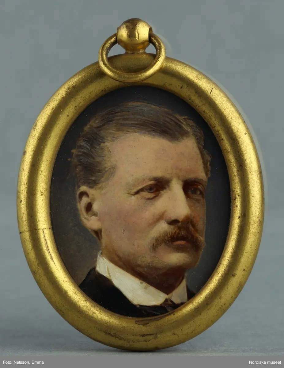 Huvudliggaren:
"a-h. Dockskåp av trä, i form av hus, i tre delar samt inventerier a/ underrede av furu på fyra ben, b/ skåpet i tre våningar med fem rum, /d h/, c/ framfasaden tjänstgör som dörr. L 115 cm, Br 70cm, H 148 cm. Bilaga. Skåpet iordningsställt i början av 1860-talet av gev. Ella von Rosen. G 13/9 1956 Överceremonimästare Joen Lagerberg, Stockholm."

Katalogkort:
"Tavla i oval ram, herrporträtt."