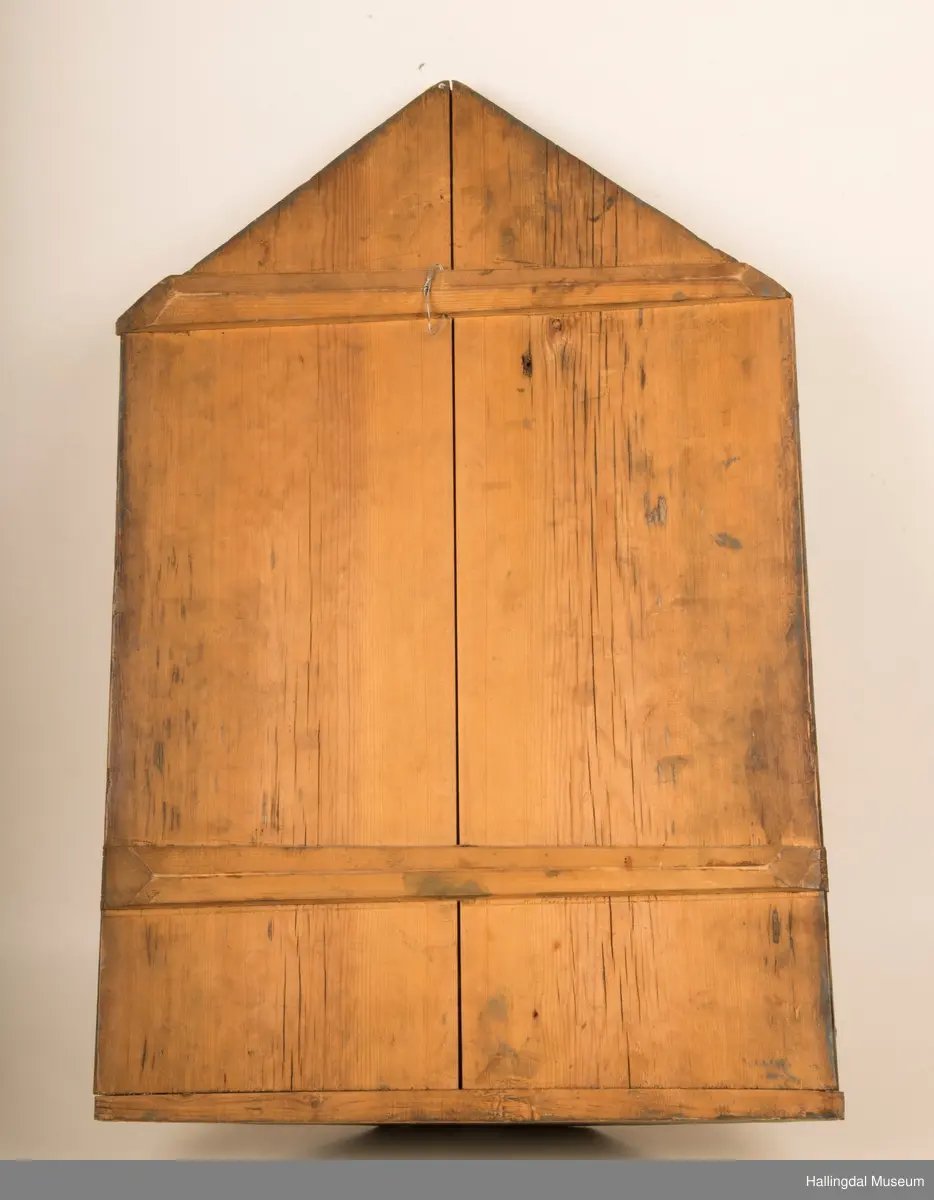 Krusifiks.  Kristusskikkelsen antagelig fra begynnelsen av 1500-årene.  Mager, senet type. Lendeklede med brukne folder. 21-20 cm. Farger, muligens fra 1846. Korset muligens fra 1846. Er festet til  tavle med gavlformet avslutning. På tavlen malt fremstilling av Maria og Johannes mellom blomster og bladverk, øverst gudsøyne og englehoder, dessuten en overmalt, men lesbar innskrift: "Bekostet af Sidsel Helgesdatter Devegge Rødningen Næs 1846.  Tavlens mål, høyde: 106 cm, bredde: 46 cm.  Har ant. tilhørt en stor engel. (Håkon Christie (1981): Norske minnesmerker, Norges Kirker, Buskerud-bind 1, side 18).  Kommer fra Nes gamle stavkirke.