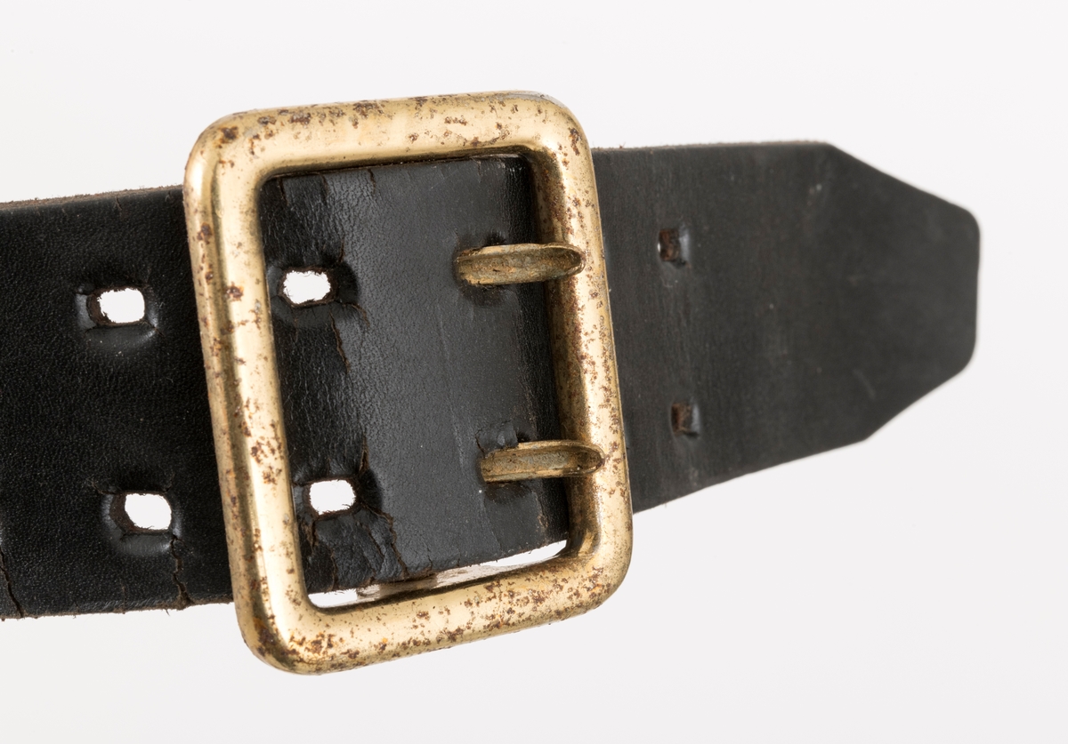 Utstyrsbelte for bruk under skogsarbeid, innkjøpt i 1984.  Sjølve beltereima er 3, 9 centimeter bredt og 112 centimeter langt.  I den ene enden er det montert en krok av dobbeltlagt, forkrummet jerntråd.  Denne kroken skal antakelig festes i ei rektangulær spenne, som er forankret i ei dobbelt hullrekke i den andre enden av beltet ved hjelp av to nåler.  Beltet er utstyrt med to bæreinnretninger.  Den ene er ei slags slire, antakelig for ei lita tømmersaks eller en enkel vendhake.  Denne komponenten er utført i svart plast.  Den øvre delen er enkel med to vertikale spalter for innfesting på beltet, mens den nedre er dobbelt med tanke på feste av redskapet den skulle holde på plass.  De to plasskivene er sammenføyd ved hjelp av fire nagler og mellomliggende lærforinger på to sider.  Fronten er merket med JOBU-selskapets logo. tre grantrær, hvorav det som står lengst til høyre er i fall.  Den andre delkomponenten til beltet er utført i rosa og svart plaststoff og har en rekatangulær form.  Midt på denne komponenten er det ei utvendig lomme med halvsirkelformet lokk med trykknapp.  Sentralt på lomma er det pålimt et sirkelformet merke, grønt med et kvitt kors i sentrum, noe som tyder på at den er beregnet på ei førstehjelpspakke.  Til høyre for denne er det et "plastbeslag" med to metallringer, antakelig for feste av målebånd, sikringsradio eller annet utstyr.  Til venstre for den nevnte lomma er det sydd inn ei vertikal spalte, sannsynligvis for skrutrekker/pluggnøkkel.  Denne delen av hoggerbeltet er merket 590500 på en rødoransj tape med svarte tall.  Baksida er foret med et gråkvitt, plastaktig stoff. 