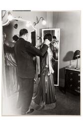 Mannekäng visar mode vid speglar i provrummet. En man, Pelle