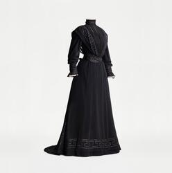 Tvådelad svart sorgklänning i jugendstil monterad på docka. 