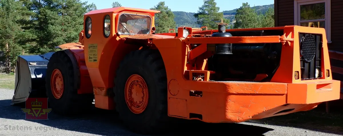 Toro 500CD. Oransje lastemaskin med fire gummihjul. Maskinen har skuffe fra Gjerstad foran og sidestilt førerhytte. Lengden på maskinen er 10,3 meter, bredden er på 2,7 meter og høyden er på 2,6 meter. Lastemaskinen har en V-12 dieselmotor med betegnelsen Deutz F 12 L413 FW som yter 277 hestekrefter. Timetelleren viser at maskinen har vært i bruk 21434 timer. Egenvekten er på 33 000 kg, og det medfølger styrekonsoll for fjernstyring av maskinen. Lasteevne på maskinen er 12 tonn.