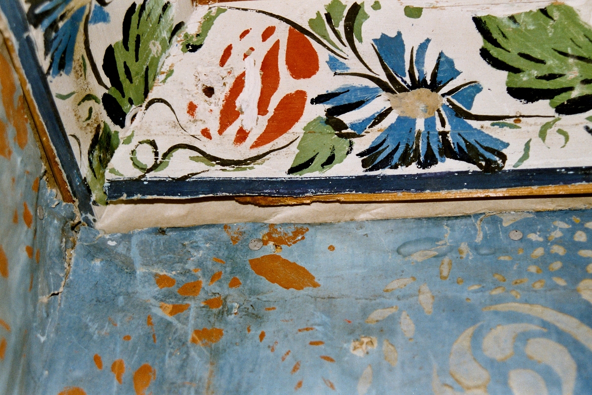 Restaureringsarbete med väggmålningar i Nils Nilsagården.
Väggmålning utförd av Anders Dahlström med hjälp av sonen Daniel Dahlström 1842. Bröstningen är stänkmålad och ovanför finns ett måleri i limfärg på papp i intensivt blått, med vita och röda schabloner, som imiterar en iristapet. Taklisten har ett band av röda och blå blommor med gröna blad.