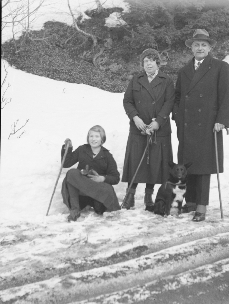 Pent kledd mann, kvinne og ung dame på spasertur med hund i Lillehammer. Fra venstre Elin Løvold Rustad, hennes mor Tora Løvold Rustad, og far Alf S. Rustad.