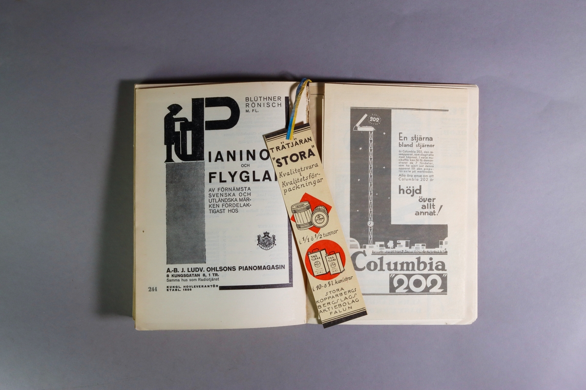 Utställningskatalog för Stockholmsutställningen 1930, huvudkatalog. Titel: "Stockholmsutställningen 1930 av konstindustri, konsthantverk och hemslöjd, maj-september : officiell huvudkatalog". Limhäftad katalog i enkelt pappband. 278 sidor med utvikbar karta över utställningsområdet. I ett inbundet blågult pappersband hänger ett bokmärke med reklam för falu rödfärg och trätjära från Stora Kopparbergslags aktiebolag Falun. Tryckt hos Almqvist & Wiksells Boktryckeri-A-B. Uppsala 1930.