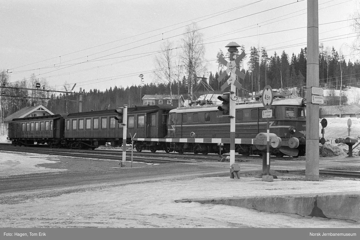 Elektrisk lokomotiv El 11 2093 med persontog til Oslo Ø ved planovergangen på Nygard stasjon