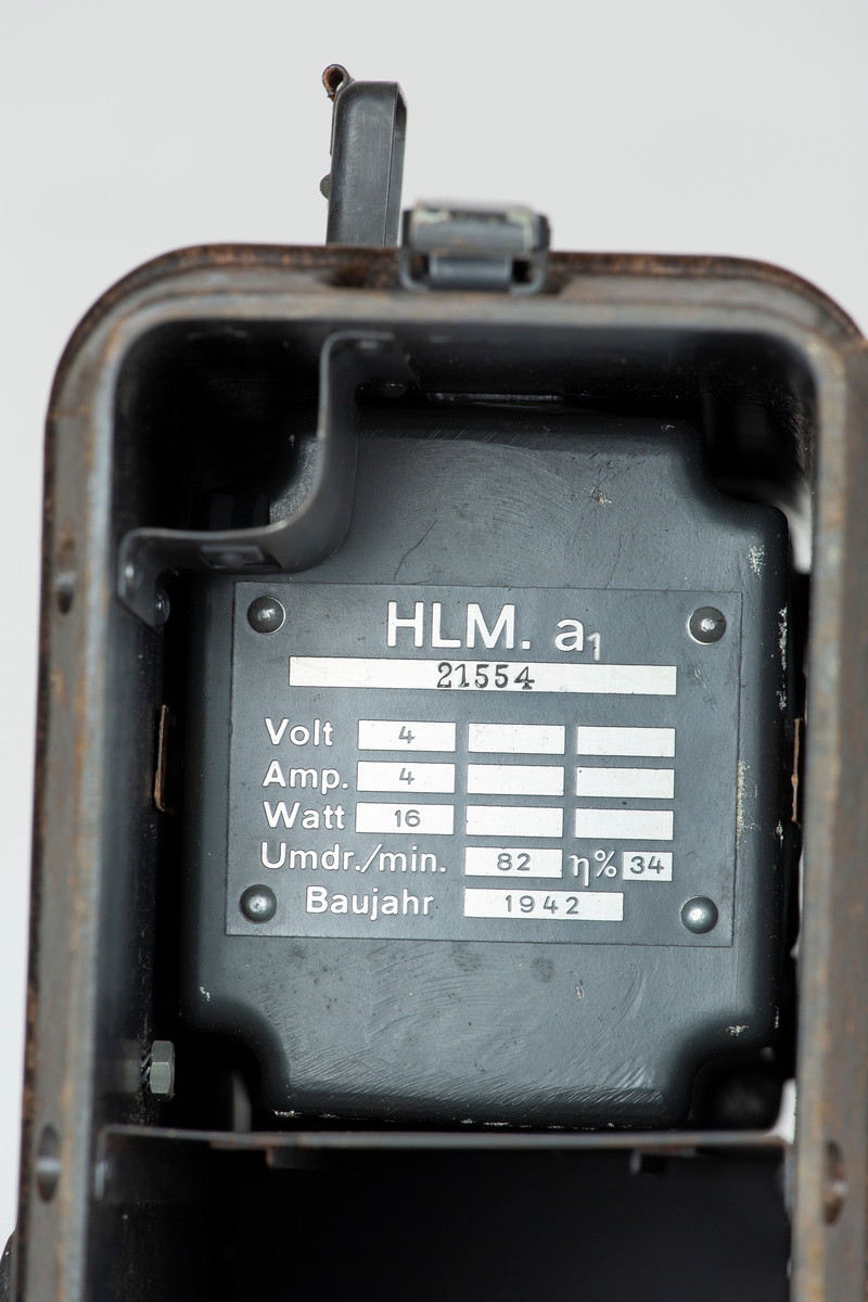 Transportabel generator med sveiv, to kabler. Tyskprodusert, antagelig fra 2. verdenskrig. Til radio og telefonsamband. Tysk bruksanvisning på sidelokk.