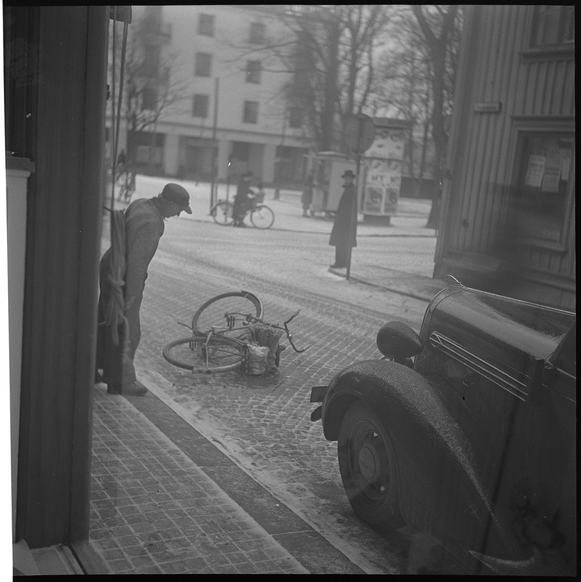 Hörnet av Kungsgatan och Östra Ringgatan, 1950

På Kungsgatan ligger en cykel omkullvält. En man står på trottoaren och tittar på cykeln. På gatan står en bil.

I fonden Järtas park och kv Järta.
Vid reklampelaren Nils Malmgrens korvkiosk.

Kurt Johanssons Cigarraffär, Kungsgatan 39 skymtar till höger i bilden.
Även 'Tobakshörnan och 'Kurts hörna'.