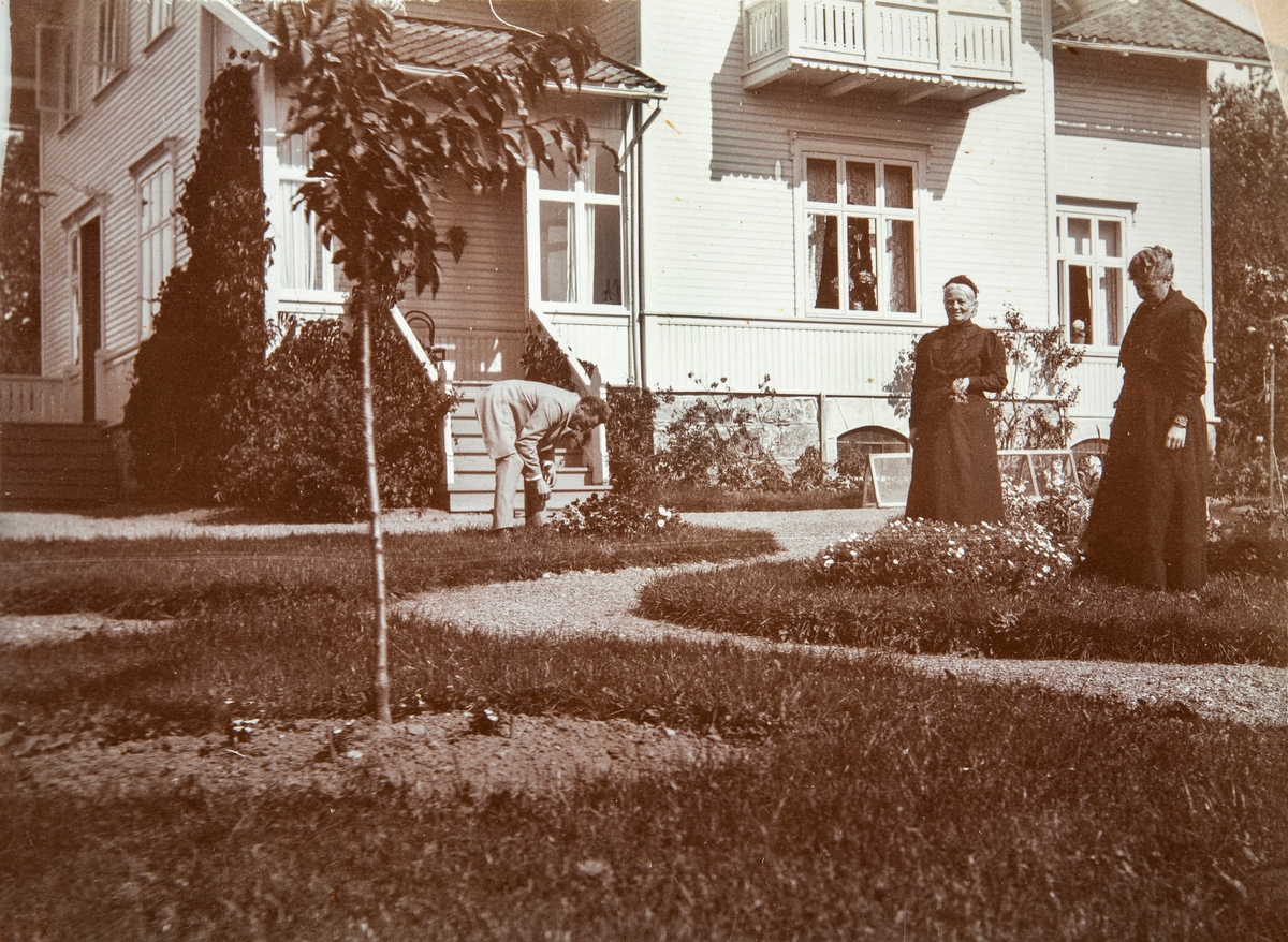 Direktør Rudolf S. Syberg og fru Julie Anna Clara Syberg i hagen utenfor direktørboligen "Maihaugen" på Aadals Brug omkring 1910. I midten Hulda Granzow (f 1842 i Lund, Sverige), på besøk fra Danmark. Direktørboligen ble oppført i 1897, og brant i 1914.