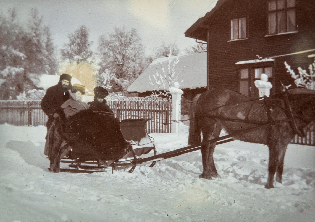 Direktørfamilien Syberg fotografert ved Ådalsbruk. Vinter.  Hest og slede, 2 damer og en mann sitter på sleden. Foran Direktørboligen til Aadals Brug