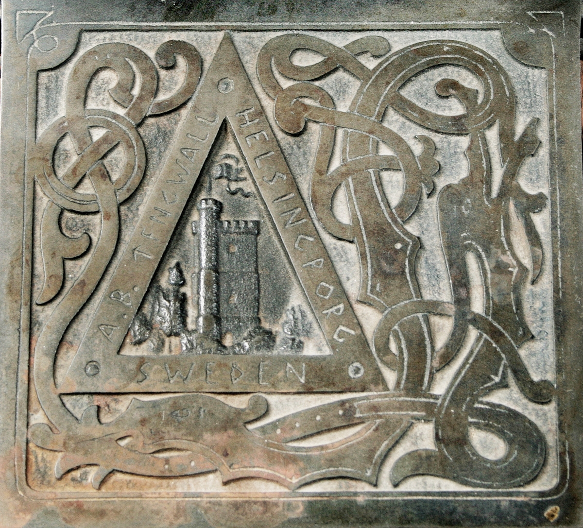 Hålstans. Med reliefdekor föreställande "fästningen kärnan" inom triangel och omgiven av drakslingor. Styrskena för olika pappersstorlekar. Märkt: A.B. TENGWALL HELSINGBORG SWEDEN. Proveniens: Eiser AB, Borås.

Äldre historik:
Kärnan är ett torn som är den enda kvarstående byggnaden av det medeltida Helsingborgs slott. Dendrokronologisk datering har visat att Kärnan byggdes på 1310-talet, då Erik Menved var kung i Danmark. Tornet är 35 meter högt och ligger i sin tur på landborgen. (Wikipedia)