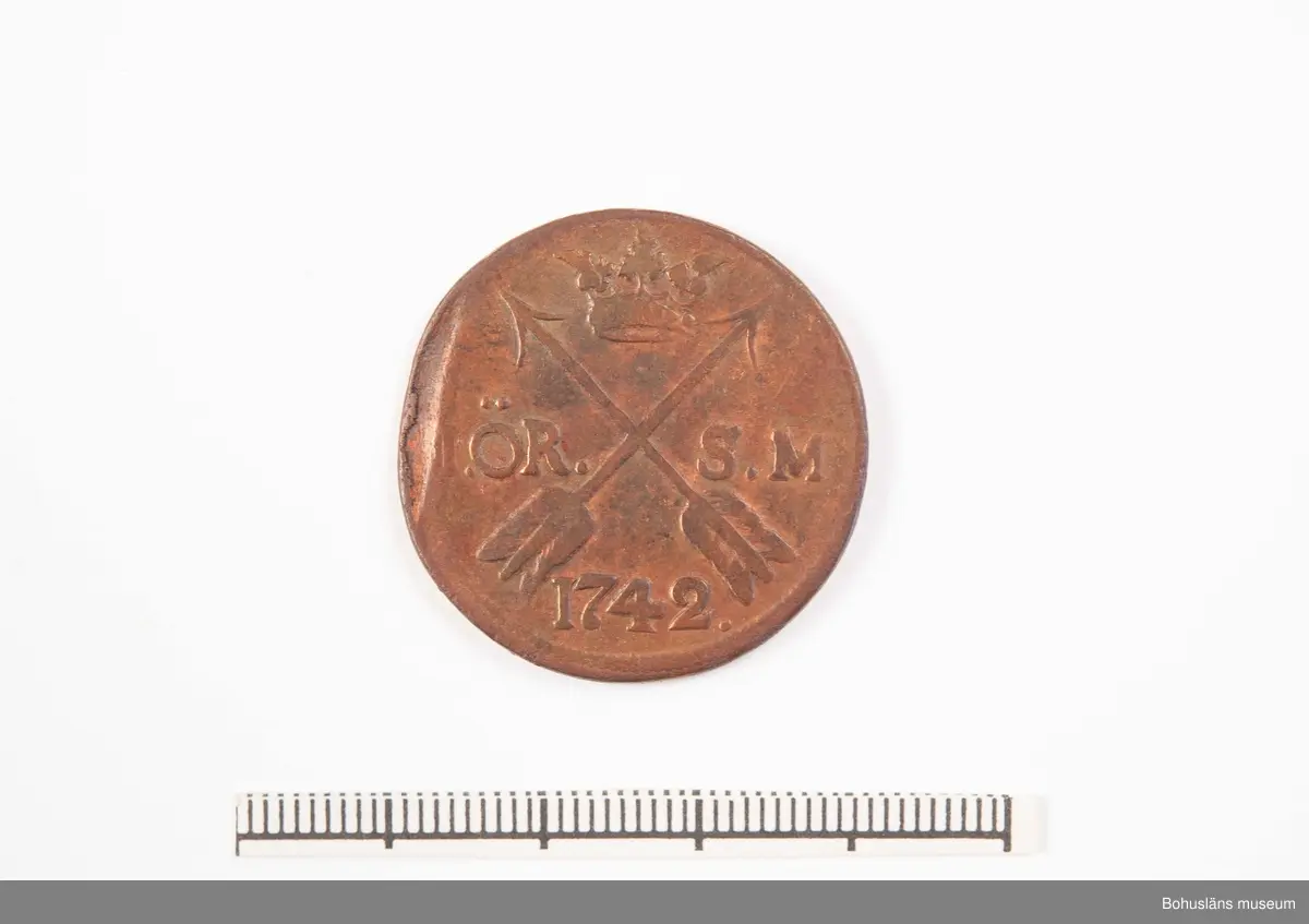 Mynt, Fredrik I.
1 öre sm 1742. Påsen märkt 2.
Funnen vid utgrävning på Bokenäs gamla kyrka.

471 Tillverkningstid 1742
410 Mått/Vikt !TJ0,1,5 DIAM3 CM
594 Landskap BOHUSLÄN