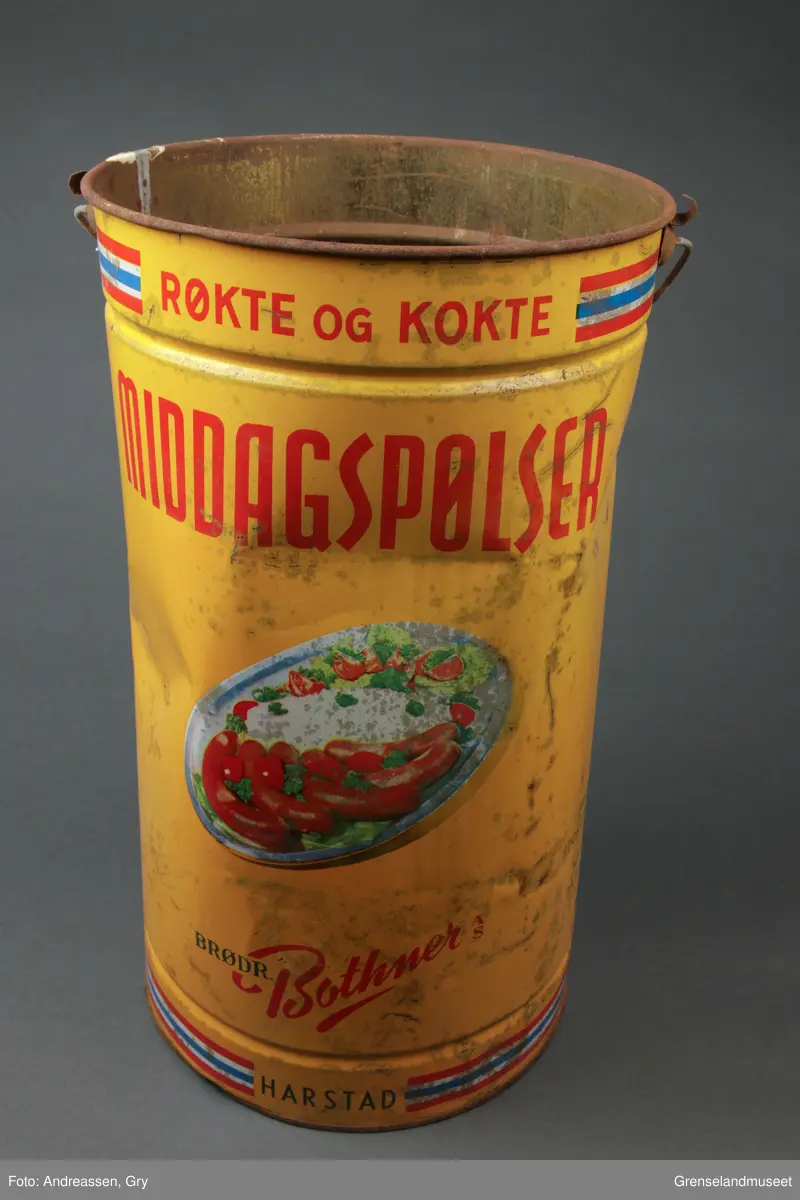 Pølsespann fra Brødrene Bothner AS, 10 kg. Bilde av fat med pølser og potetstappe og tomater. Randdekor oppe og nede med fargene fra det norske flagget. Det er begynt å ruste hull i bunnen av spannet.
Oppi spannet ligger det flere forskjellige gjenstander:
- 1 Dekorert skaft i sølv, til bestikk. Merket med 830 S
- 1 knivblad, rustent
- 2 Volter, 6 cm lange
- 1 større skaft i lakkert tre med en metallring rundt hull for feste. Skaftet er 25,5 cm langt.
- 10 halvskiver i et hardt tremateriale. To av dem er delvis ødelagt, den ene er i to deler. Diameter nå de sette sammen er ca 20-22 cm. Størrelsen varierer litt.