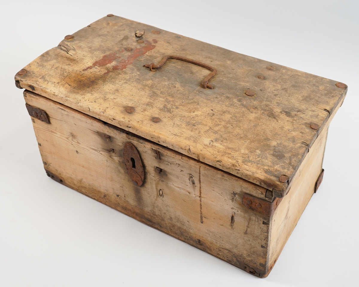 Større skrin av tre sett saman av breie bord. Hjørna er halde saman med "sinktapper" forsterka med jarnvinkler. Botn er lagt inn med fals til sidene. Det er spor etter eit mindre rom  øverst på venstre side i skrinet. På loket er det mykje spor etter kniv som kan tyde på at dette har vore nytta som ein form for skjærefjøl.