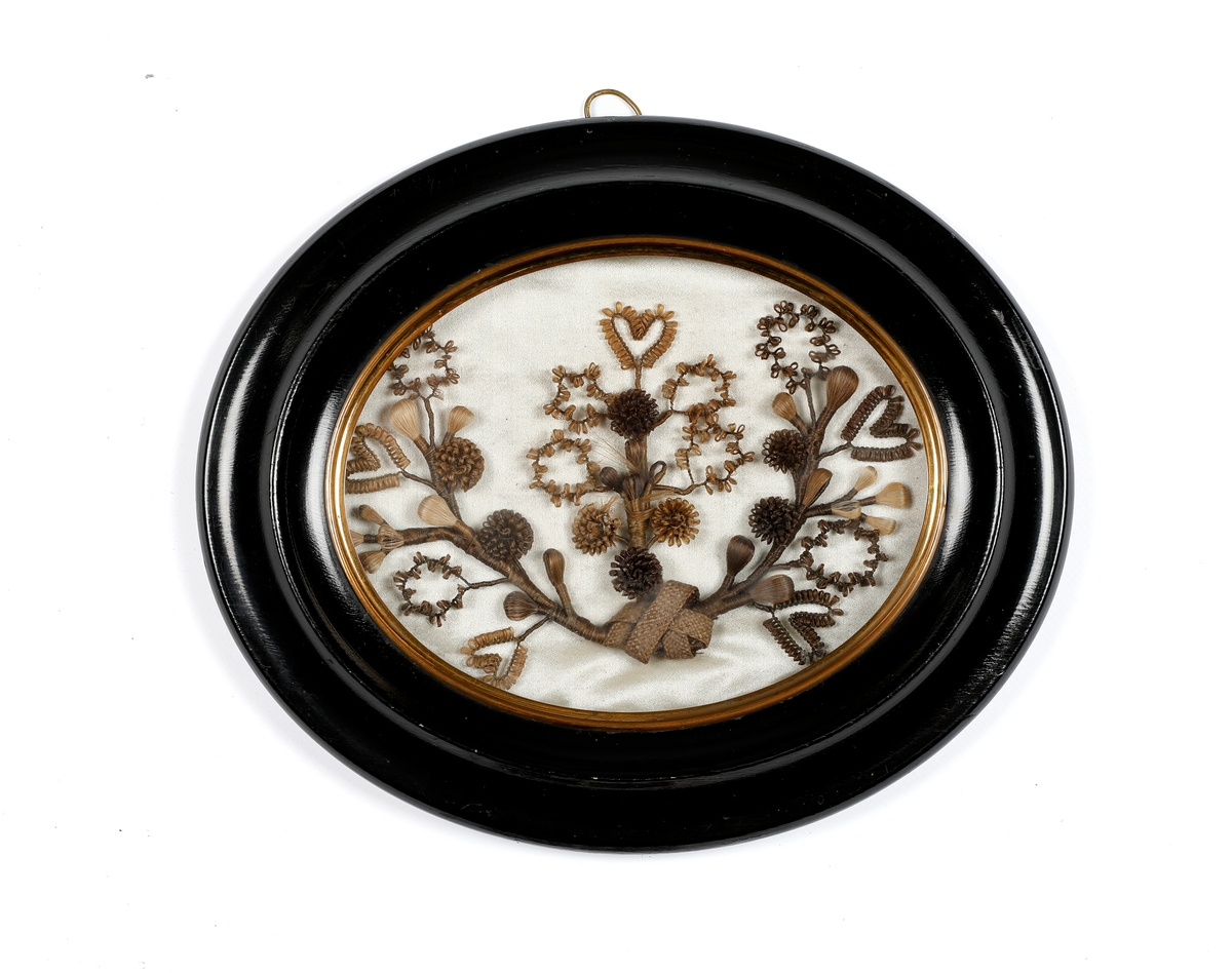 Hårfletting i ramme. Blomstermotiv. Sydd fast på silkestoff.