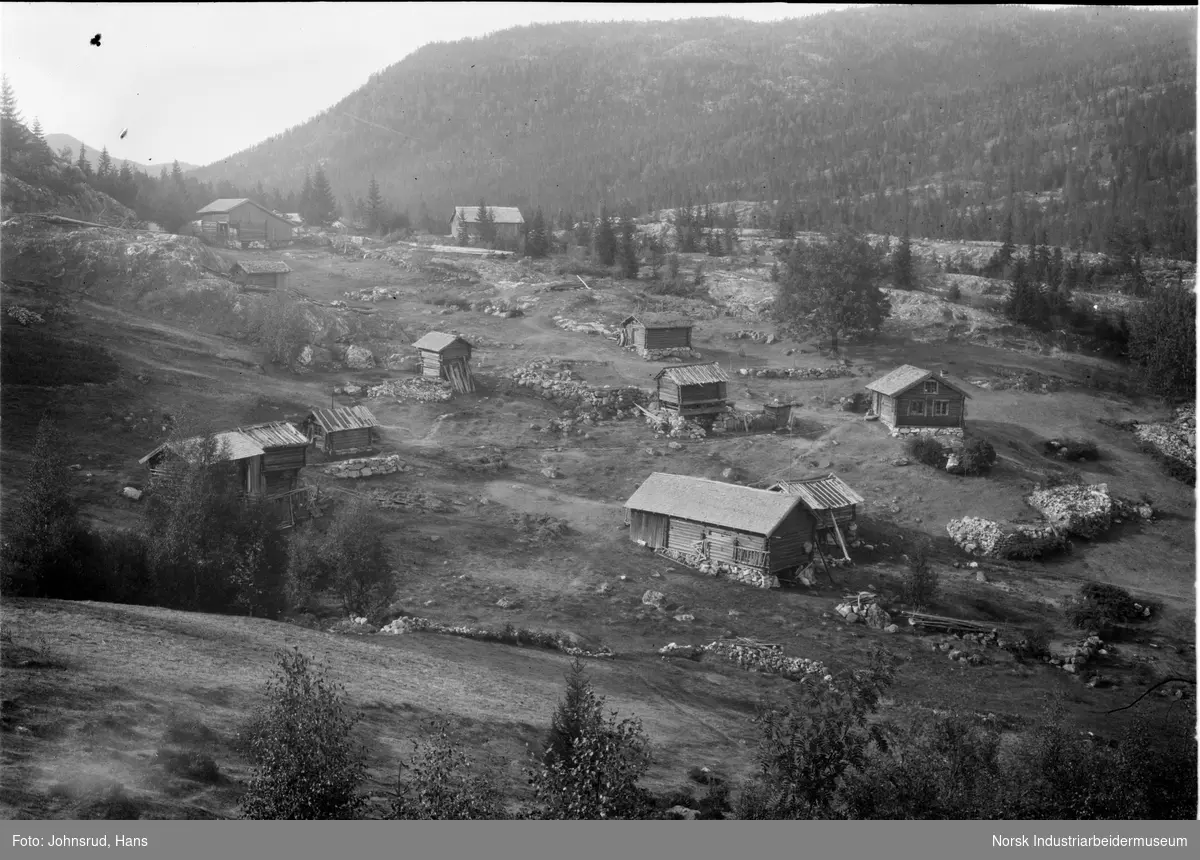 Husmannsplass i Tuddal bestående av ti bygninger i et fjellandskap.