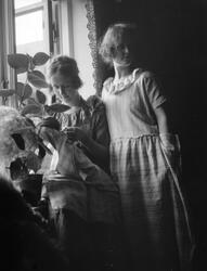 To kvinner ved vinduet.