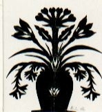 Motivet är klippt ur svart papper och föreställer ett antal blommor i en vas.