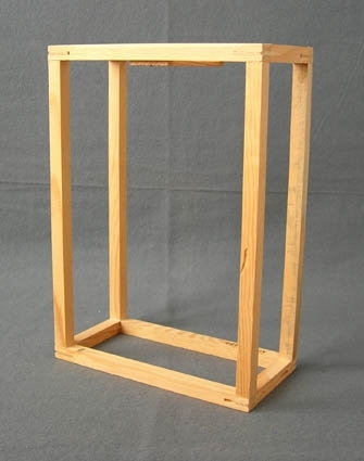 Rektangulär ram till lampskärm i furu. Ramen är gjord i fyrkantstav i måtten 11 x 11 mm. Ramen är limmad och spikad och hållaren för sockeln är 80 x 32 x 3 mm med ett 10 mm hål, även denna del är limmad och spikad.