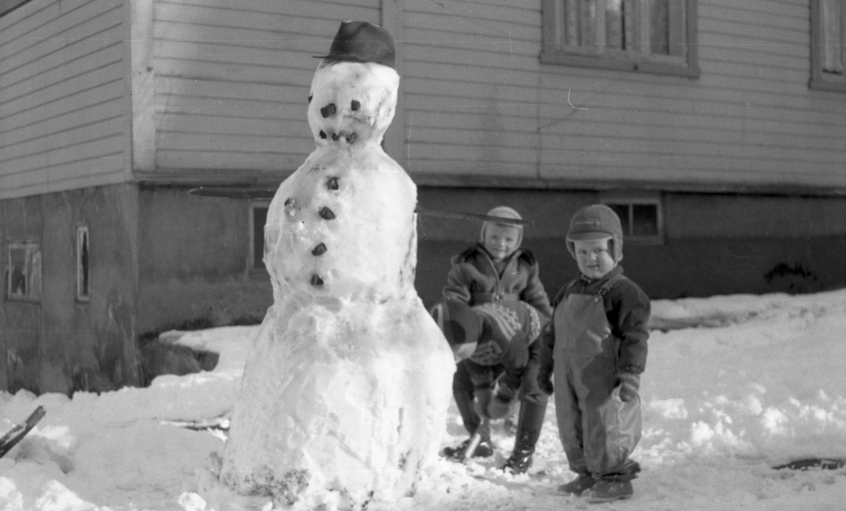 Barn leker med snømann.