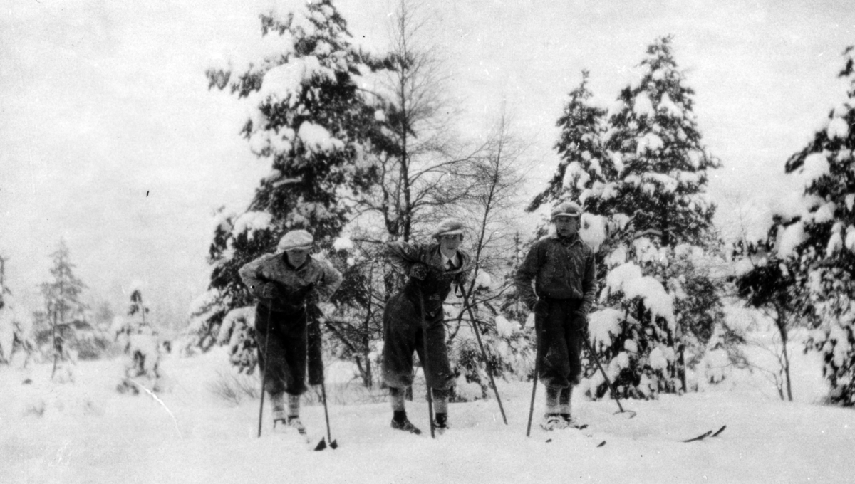 Tre unge menn på skitur.