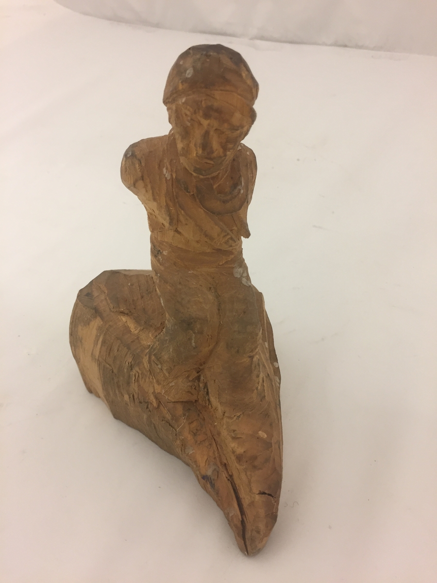 Sitjande mannsfigur.