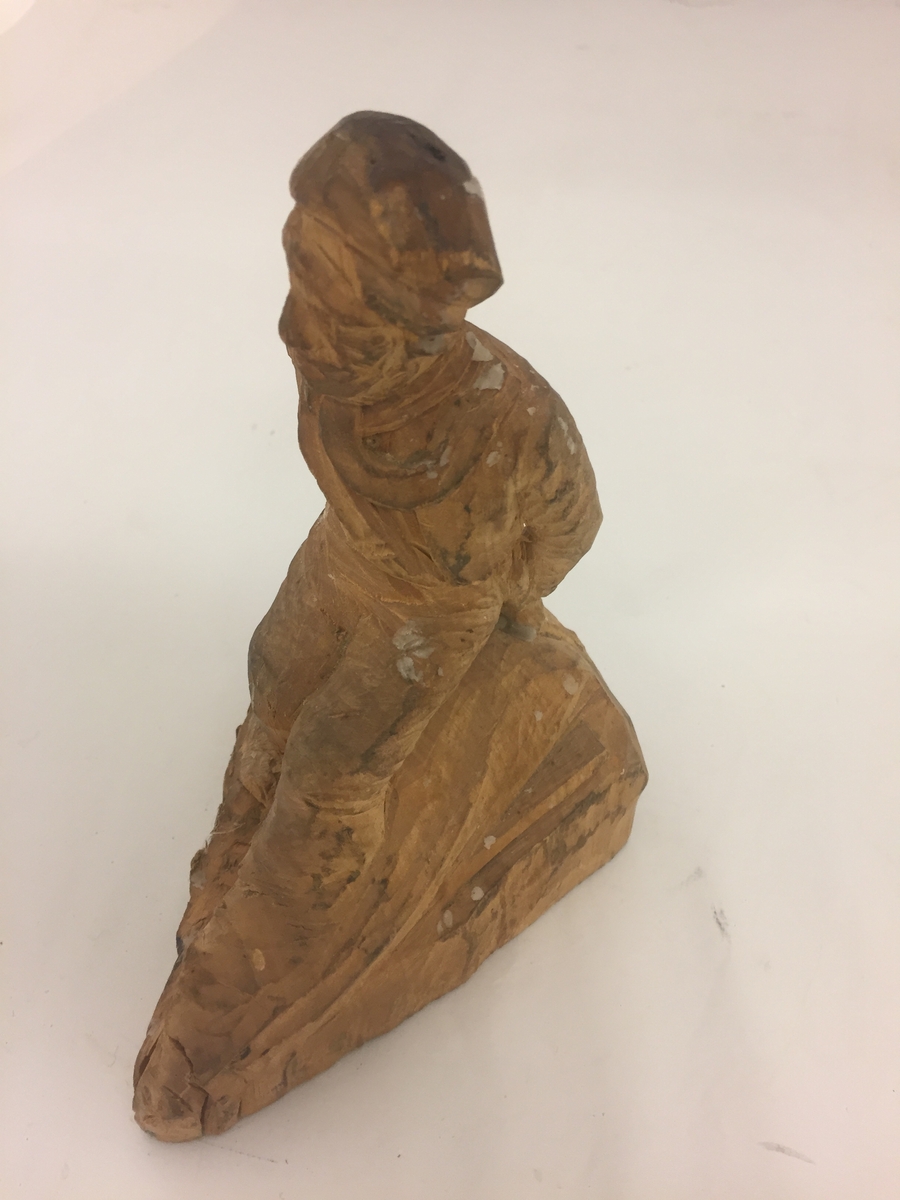 Sitjande mannsfigur.