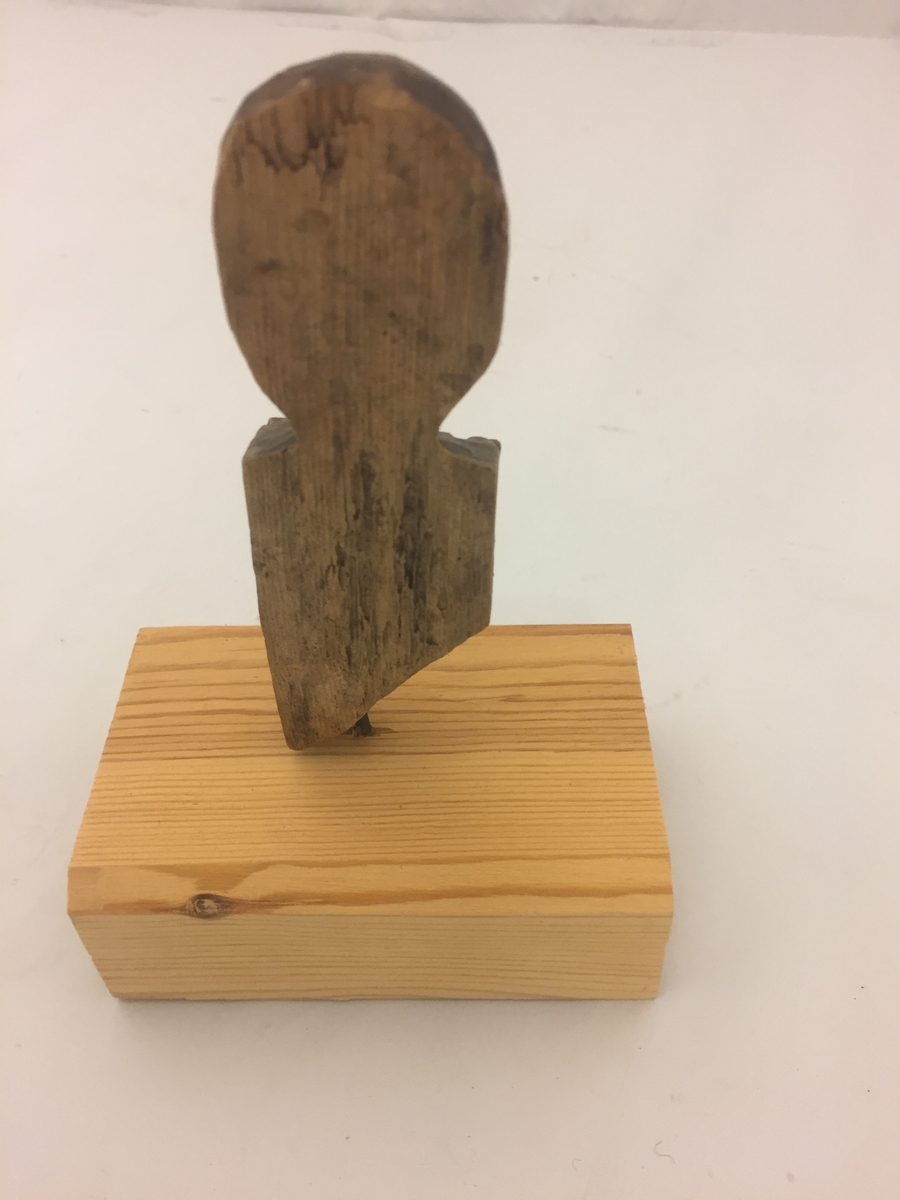 Liten figur forma som eit mannshovud, Kloss sett på i seinare tid, festa med spiker. Denne er fjerna, men figuren har hol i botn etter spikeren.