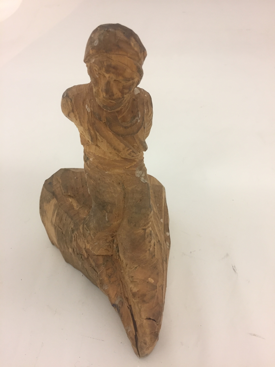 Sitjande mannsfigur.