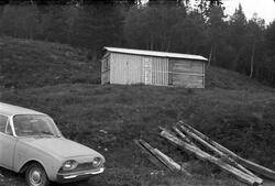 En bil, plank og et skur ved Krossobanens Øvre stasjon eller