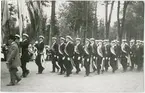 Studentkören tågar in i Botaniska trädgården vid vårfesten, Uppsala 1914