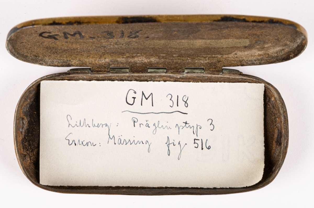 Snusdosa, av mässing, avlång, platt, med almanack i relief på sidorna. Mycket sliten.