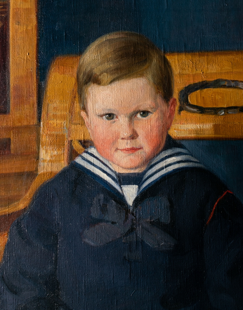 Pojken Åke Ericson, 4 år, sitter iklädd en sjömanskostym i en länsstol i ett rum, i bakgrunden till vänster en bokhylla, blå vägg och blå matta. Konstnär är den då välkända porträttören Anna Ödman. Åke blev 1917 förebilden till reklamfiguren PIX-pojken som var klädd i sjömanskostym. Han är son till fabrikör, direktör och Nederländernas konsul i Gävle Wilhelm Ericson och hans fru Lenna Flensburg.  Pappa Wilhelm Ericson var ägare av den stora godisfabriken PIX i Gävle. Åke avled 18 år gammal 1932 i en bilolycka på Norrlandet utanför Gävle.