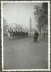 Bilden visar engelska soldater i paraduniformer till häst som rider på Horse Guards road i London. I bakgrunden syns monumentet 