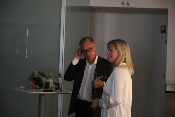 Direktør for Norsk vegmuseum og en mann snakker til publikum under åpning av utstilling