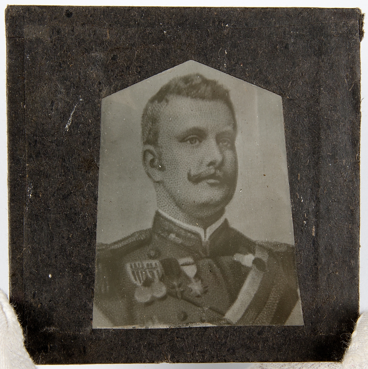 Tjugoåtta skioptikonbilder med motiv från bl.a. olika historiska händelser och sagor. Merparten i färg. Vissa skioptikonbilder, såsom avbildade personer, i sv/v. De flesta har en rosa, gul eller svart tejp som håller ihop de två glasplåtar i vilka motivet är fastsatt i. Vissa av bilderna är numrerade eller märkta med en bokstav.