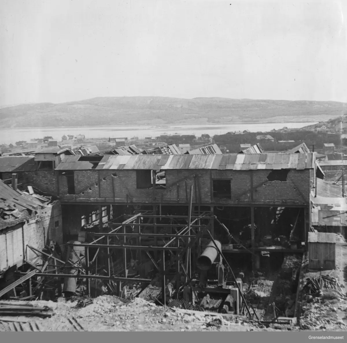 Under rivingen av brikettverket i Kirkenes, 18. juni 1948. Byen og fjorden ses i bakgrunnen.