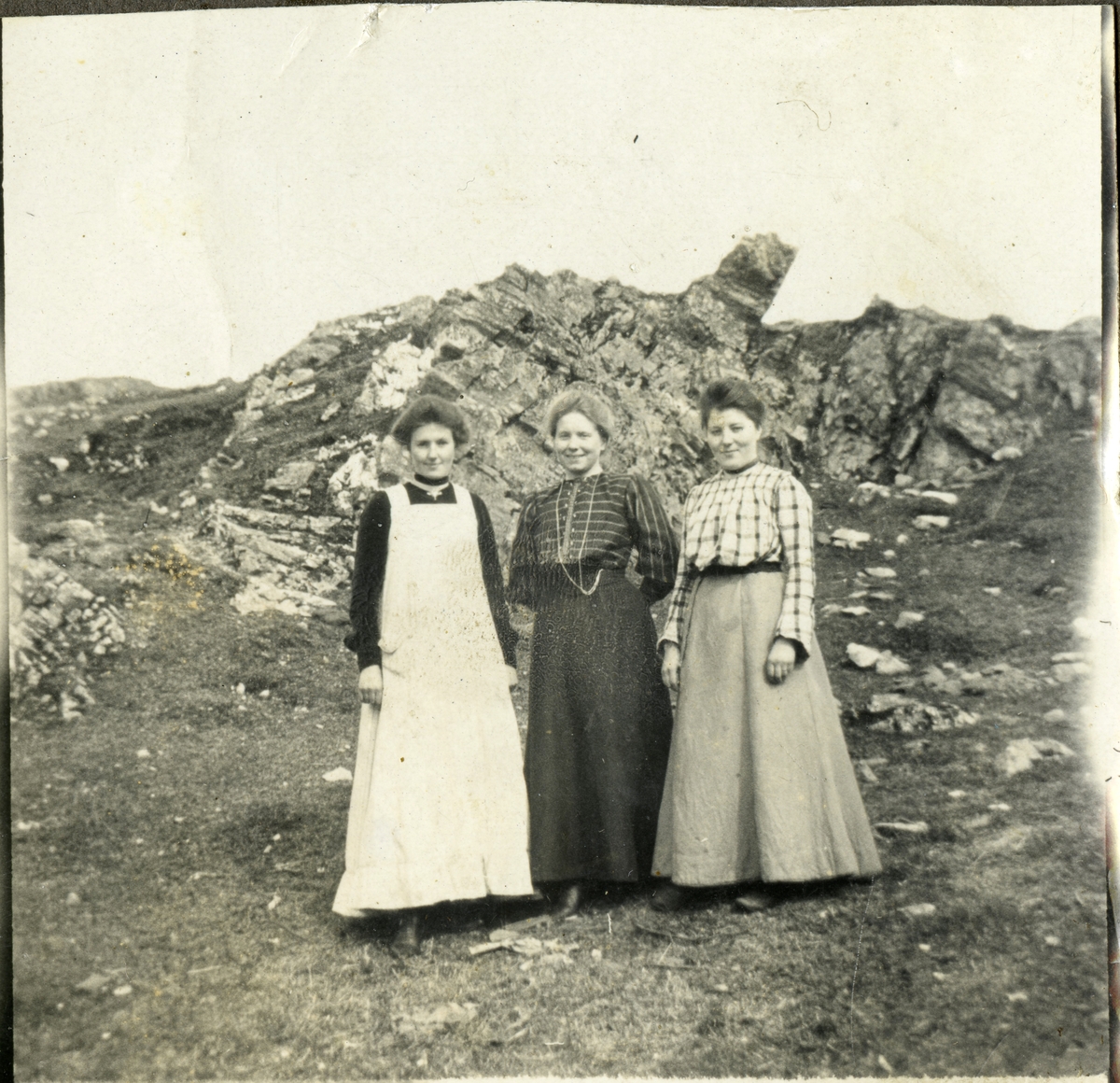 Tre kvinner foran en fjellknaus.