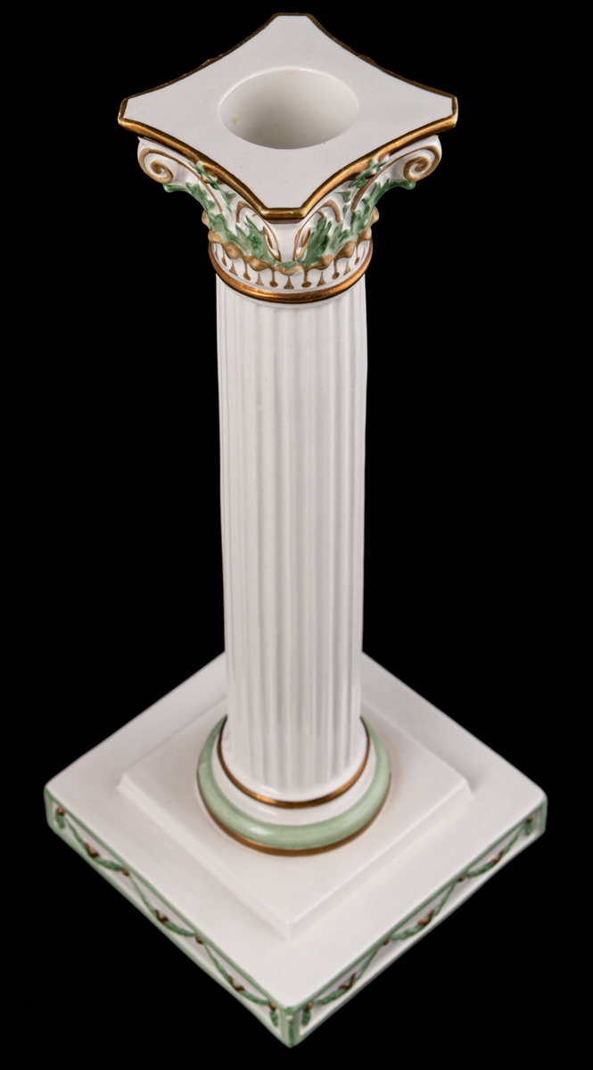 Kolonnformad ljusstake av flintgods, vit med dekor i guld och grönt.