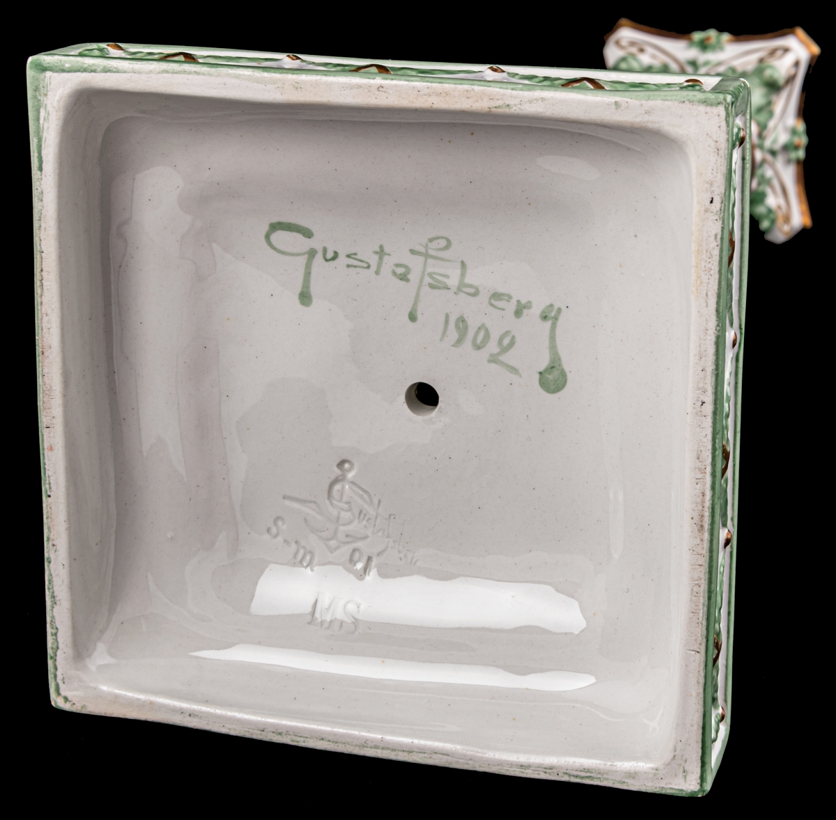 Kolonnformad ljusstake av flintgods, vit med dekor i guld och grönt.