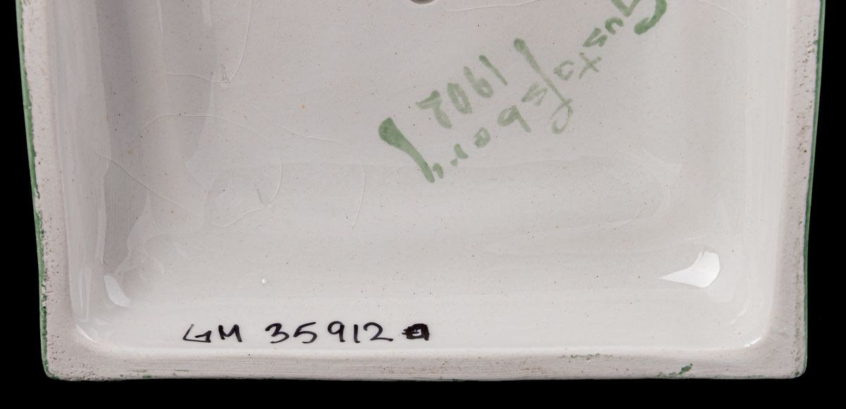 Kolonnformad ljusstake av flintgods, vit med dekor i guld och grönt.