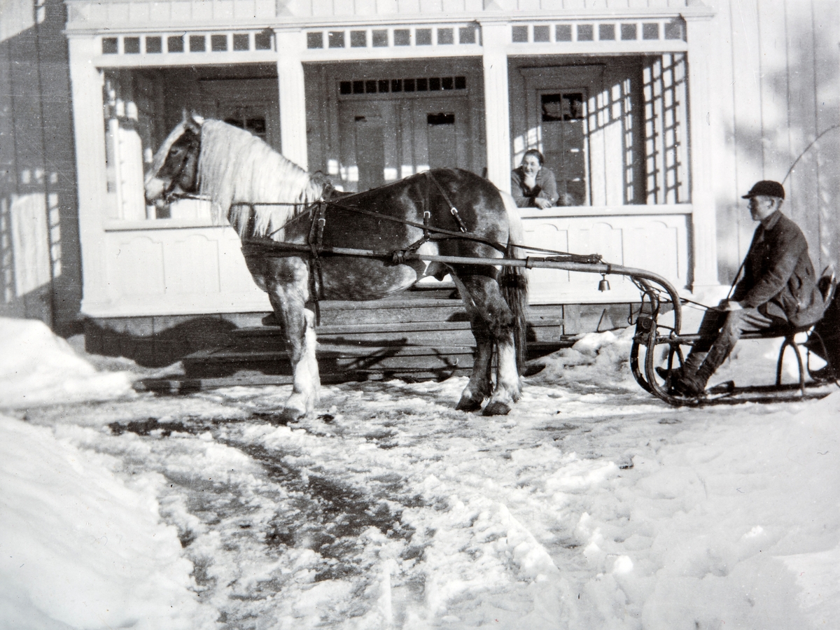 Ottestad Nordre, Ottestad, Stange. Vinter, snø, hest og slede.
Hesten Rømerra, og kusk Oddvar Gjestvang (1909 - 2002) på sleden. Ella Gjestvang står på verandaen å følger med.