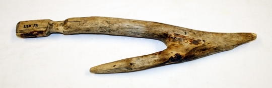 Trekrok. Bearbeid av ei grein. Lengste del har skåret innsnevring. Kroken ender i en spiss.