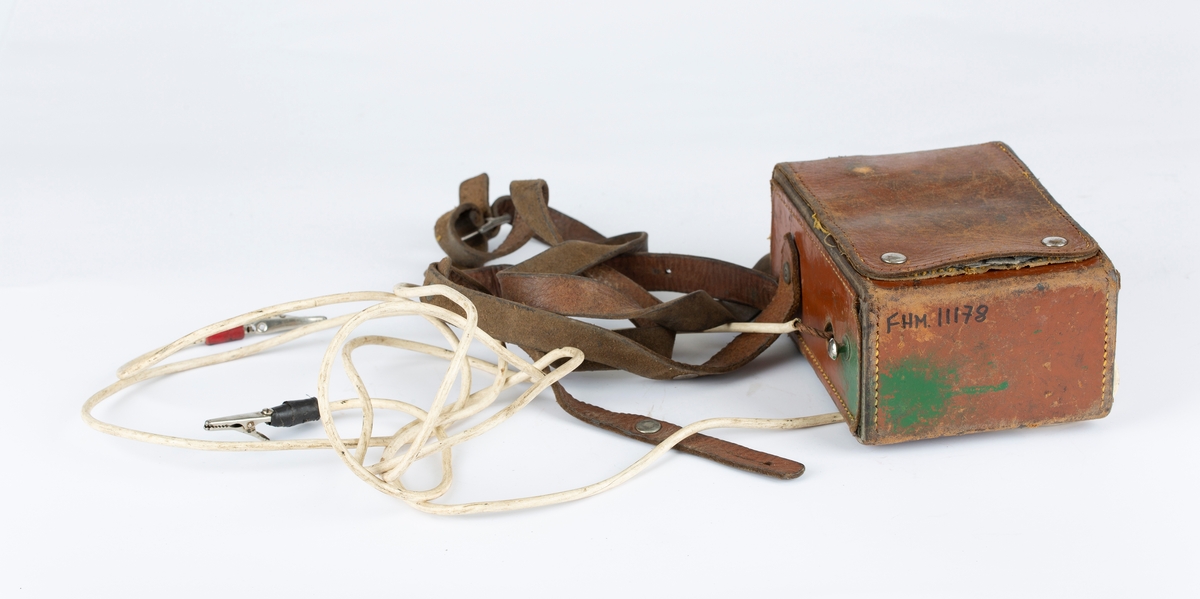 Voltmeter i læretui.To kabler med krokodilleklemmer. Måler også Ohm. Brunt etui, sort måleinstrument.