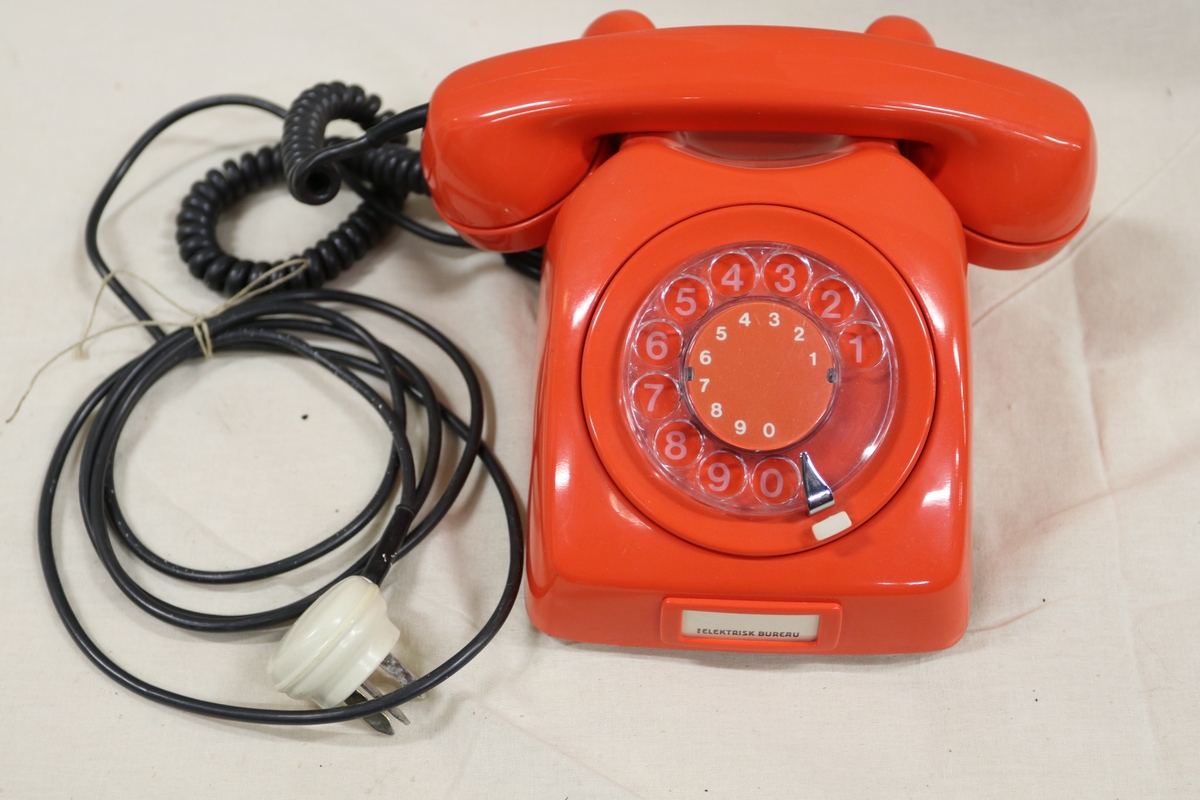 Bordtelefon i oransjerød plast.