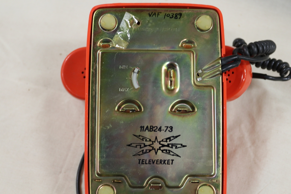 Bordtelefon i oransjerød plast.