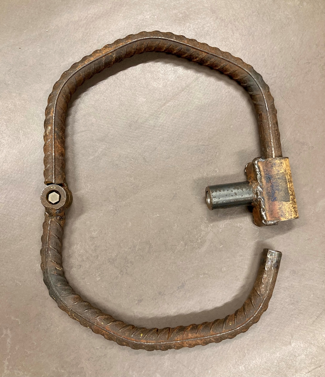 To korte lenker, en jernring, to rør. Rørene er såkalte "muffer". Jernringen er et midjejern. Nøkkelen til midjejernet medfølger.